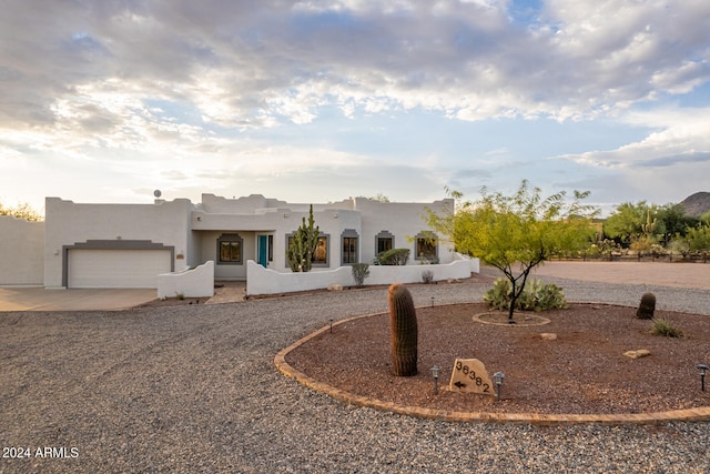 pueblo-style house featuring a garage