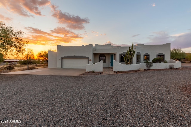 pueblo revival-style home with a garage