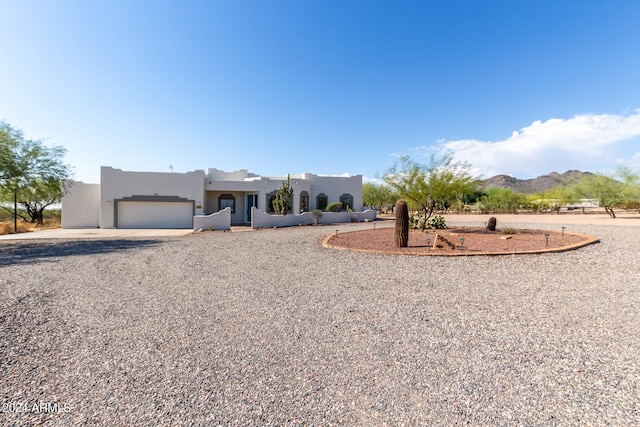 pueblo-style home featuring a mountain view and a garage