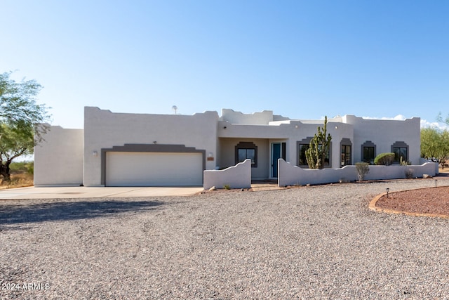 pueblo revival-style home with a garage