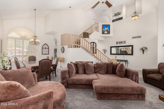 carpeted living room with ceiling fan with notable chandelier, high vaulted ceiling, and beam ceiling