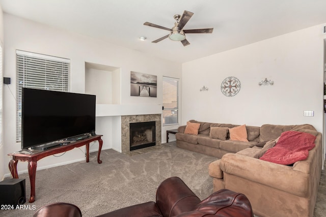 living room featuring ceiling fan, a fireplace, and carpet floors