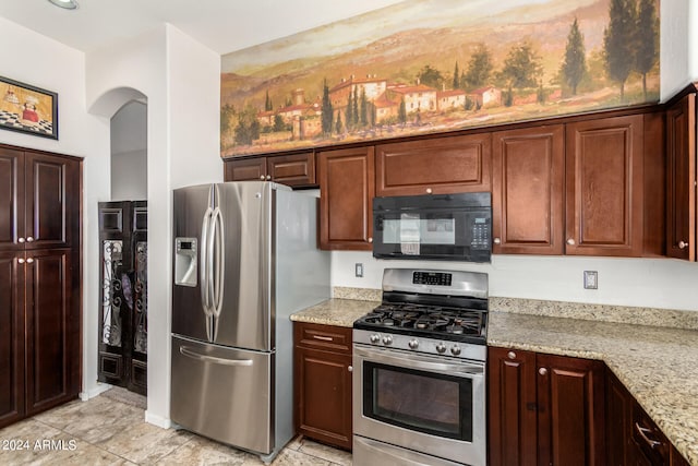 kitchen with appliances with stainless steel finishes and light stone counters