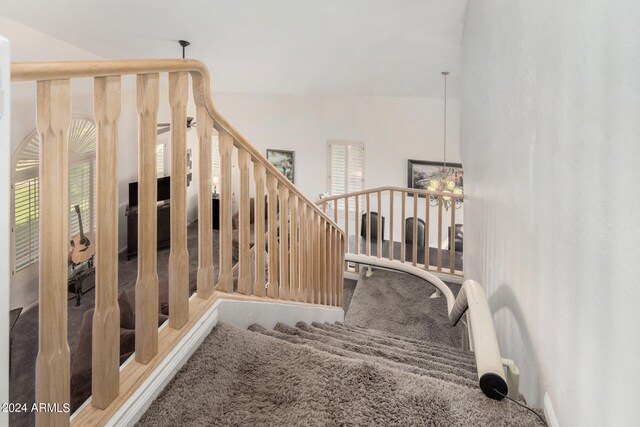 stairs featuring vaulted ceiling and carpet flooring