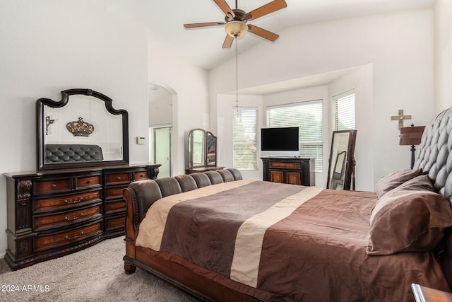 carpeted bedroom with multiple windows, ceiling fan, and vaulted ceiling