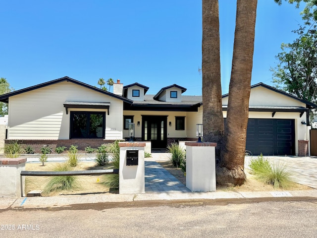 3021 N 47th St, Phoenix, AZ 85018 - view of front facade featuring an attached garage, brick siding, and driveway