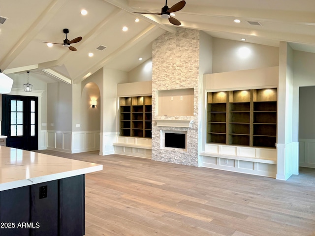 3021 N 47th St, Phoenix, AZ 85018 - unfurnished living room with a ceiling fan, a decorative wall, beam ceiling, arched walkways, and a wainscoted wall