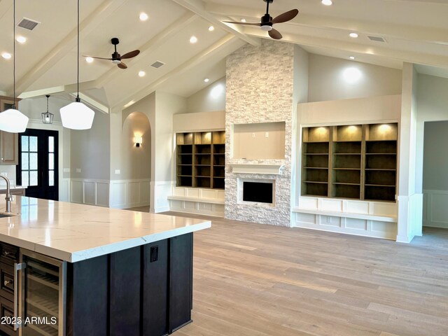 3021 N 47th St, Phoenix, AZ 85018 - kitchen featuring ceiling fan, wine cooler, wainscoting, open floor plan, and light wood-style flooring