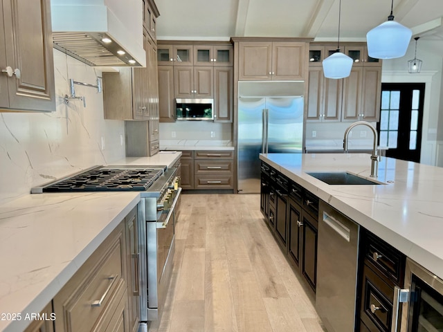 3021 N 47th St, Phoenix, AZ 85018 - kitchen with high end appliances, wall chimney exhaust hood, light wood-style flooring, decorative light fixtures, and glass insert cabinets