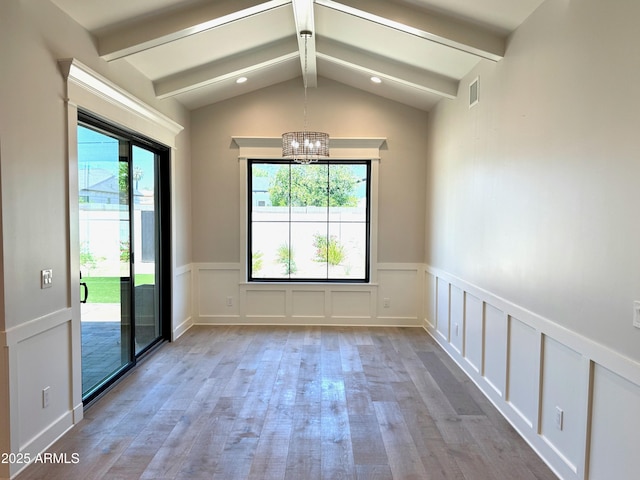 3021 N 47th St, Phoenix, AZ 85018 - empty room with healthy amount of natural light, wood finished floors, a chandelier, a decorative wall, and wainscoting