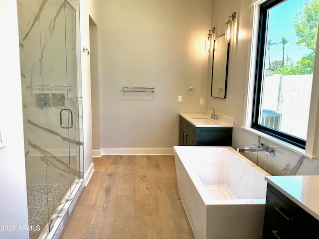 3021 N 47th St, Phoenix, AZ 85018 - bathroom with wood finished floors, vanity, a marble finish shower, and a freestanding tub