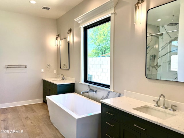 3021 N 47th St, Phoenix, AZ 85018 - full bathroom featuring a marble finish shower, wood finished floors, a freestanding bath, two vanities, and recessed lighting