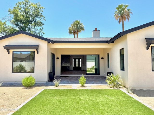 3021 N 47th St, Phoenix, AZ 85018 - back of house with a yard, stucco siding, and a chimney