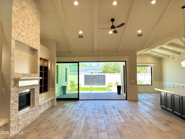 3021 N 47th St, Phoenix, AZ 85018 - unfurnished living room featuring ceiling fan, built in shelves, light wood-style flooring, beamed ceiling, and a fireplace