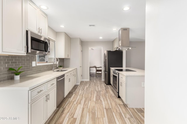 kitchen featuring extractor fan, appliances with stainless steel finishes, sink, white cabinets, and decorative backsplash