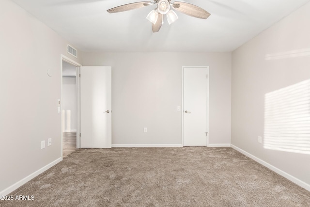 unfurnished bedroom with a ceiling fan, carpet flooring, baseboards, and visible vents