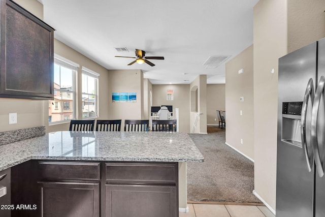 2049 N 77th Dr, Phoenix, AZ 85035 - kitchen with dark brown cabinets, ceiling fan, stainless steel fridge with ice dispenser, a peninsula, and visible vents
