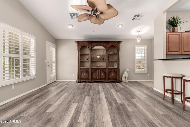 unfurnished living room featuring lofted ceiling, hardwood / wood-style flooring, and ceiling fan