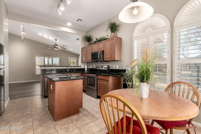 kitchen featuring electric stove, light tile patterned floors, a center island, vaulted ceiling, and kitchen peninsula