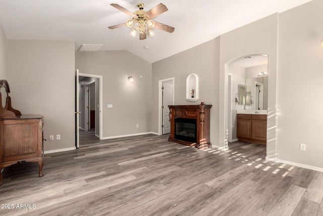 living room featuring ceiling fan, lofted ceiling, and wood-type flooring