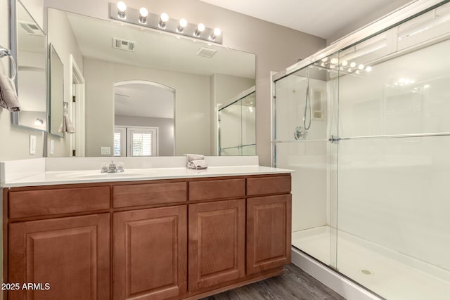 bathroom featuring hardwood / wood-style flooring, vanity, and an enclosed shower