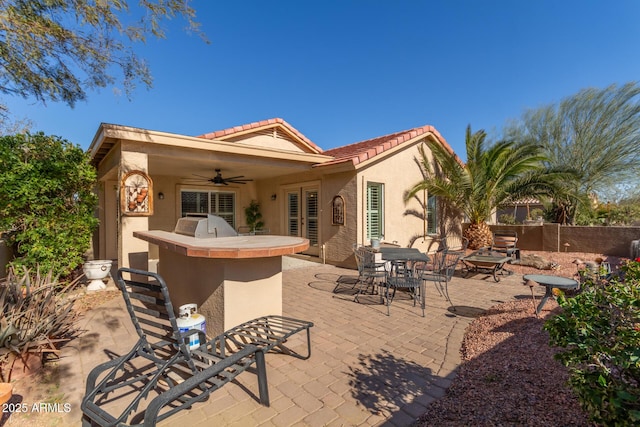 back of house with ceiling fan, an outdoor bar, and a patio