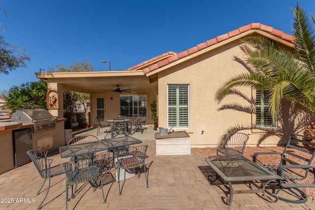 view of patio with grilling area, ceiling fan, and exterior kitchen