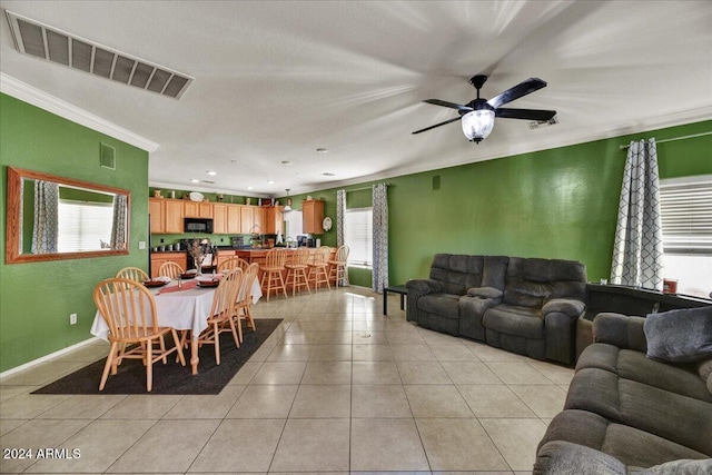 tiled living room featuring ceiling fan and ornamental molding