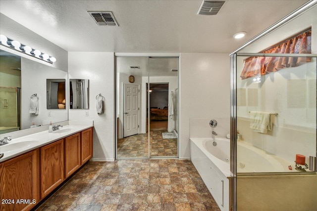 bathroom featuring a textured ceiling, vanity, and a tub