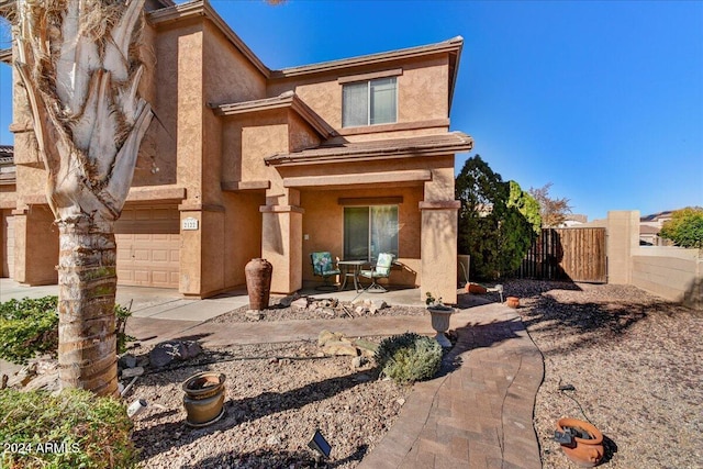 back of house with a patio area and a garage