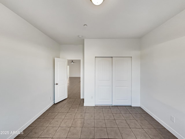 unfurnished bedroom featuring light tile patterned floors and a closet