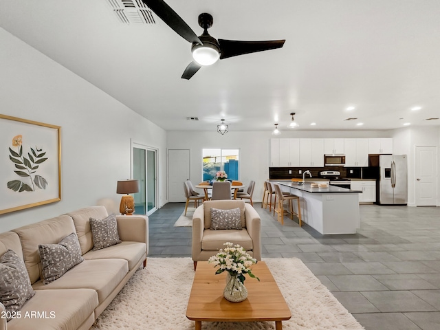 living room with ceiling fan and sink