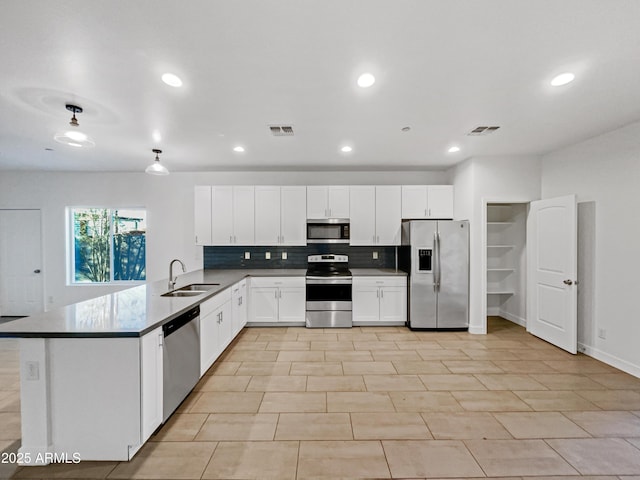 kitchen featuring white cabinets, sink, tasteful backsplash, kitchen peninsula, and stainless steel appliances