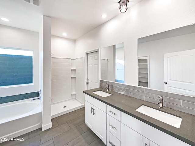 bathroom with vanity, backsplash, and plus walk in shower