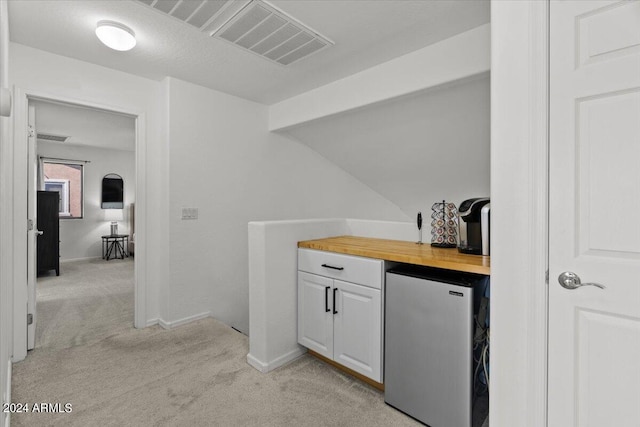 bar featuring white cabinets, butcher block countertops, light colored carpet, and stainless steel fridge