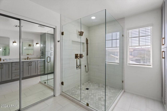 bathroom featuring vanity, tile patterned floors, and a shower with shower door