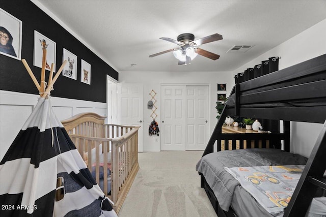 bedroom featuring a closet, a textured ceiling, carpet flooring, and ceiling fan