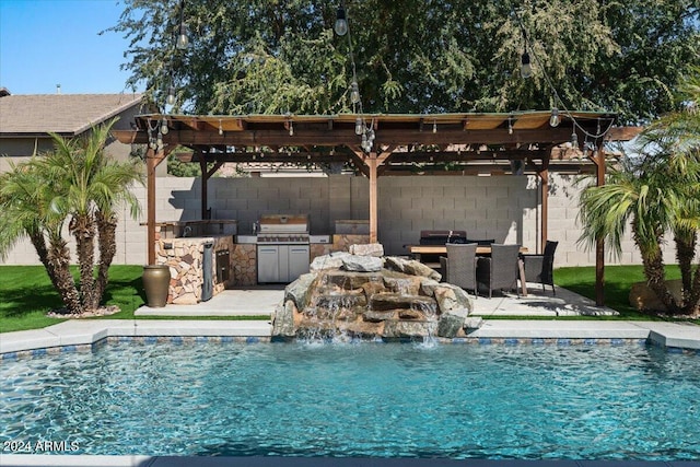 view of swimming pool featuring a grill, an outdoor kitchen, a pergola, pool water feature, and a patio