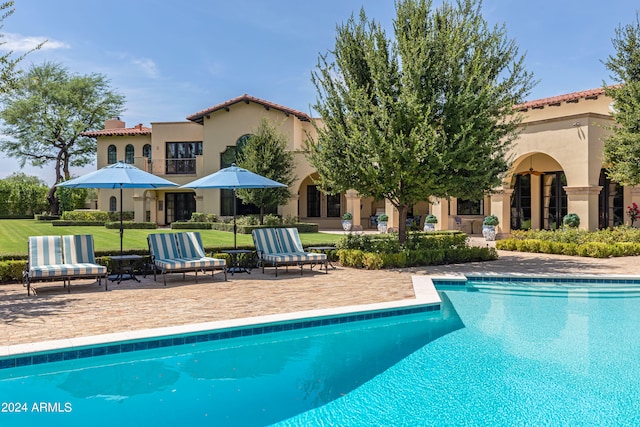 view of pool with a patio and a yard