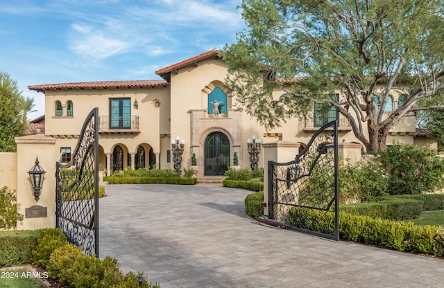 mediterranean / spanish-style house featuring a balcony and french doors