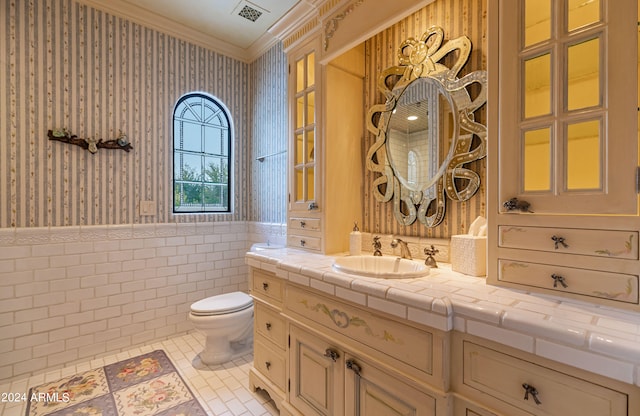 bathroom with ornamental molding, vanity, toilet, and tile patterned floors