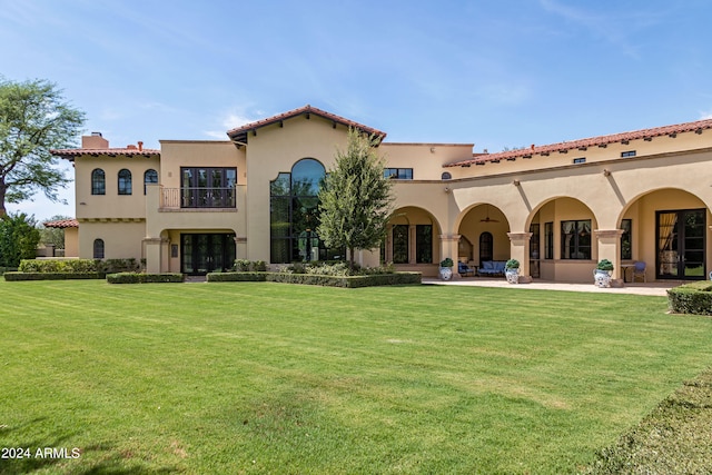 rear view of property with a yard and a patio