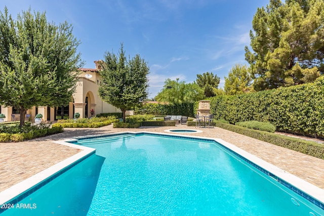 view of pool with a patio and an in ground hot tub