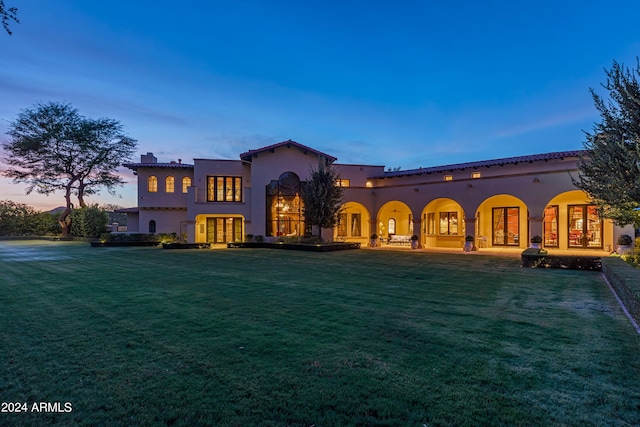 mediterranean / spanish house featuring a lawn and french doors