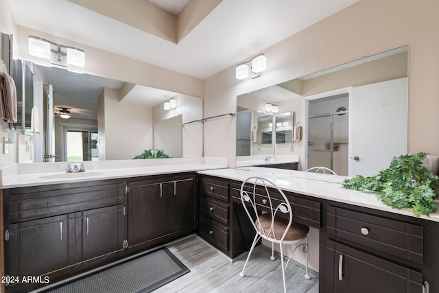 bathroom featuring wood-type flooring, vanity, and a shower with shower door