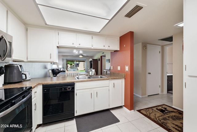 kitchen with white cabinets, black appliances, light tile patterned floors, and sink