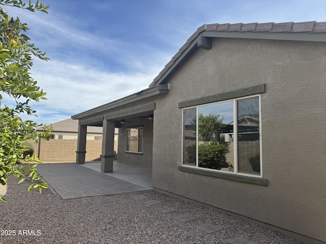 exterior space featuring ceiling fan and a patio area