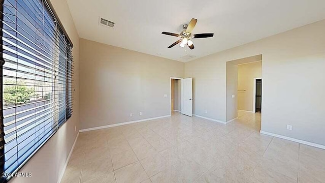 spare room with ceiling fan and light tile patterned floors