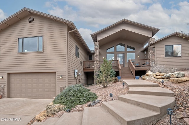 view of front of home with a garage, driveway, stairway, and a deck