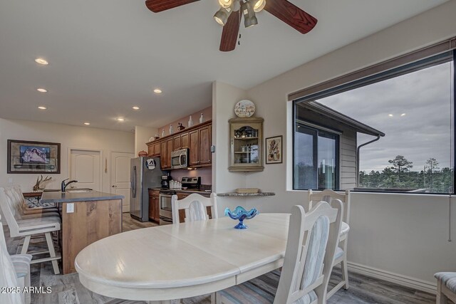 dining space with ceiling fan, light wood finished floors, and recessed lighting